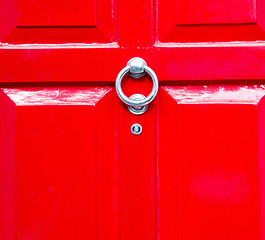 Image showing red handle in london antique brown door  rusty  brass nail and l