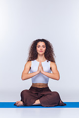 Image showing Studio shot of a young fit woman doing yoga exercises.