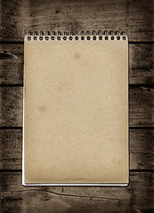 Image showing Closed spiral Note book on a dark wood table