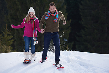 Image showing couple having fun and walking in snow shoes