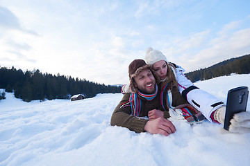 Image showing romantic couple have fun in fresh snow and taking selfie
