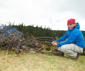 Image showing hiking man prepare tasty sausages on campfire