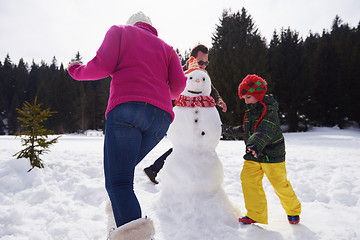 Image showing happy family building snowman