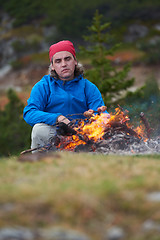 Image showing hiking man prepare tasty sausages on campfire