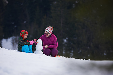 Image showing happy family building snowman