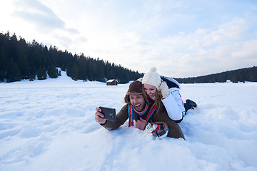 Image showing romantic couple have fun in fresh snow and taking selfie