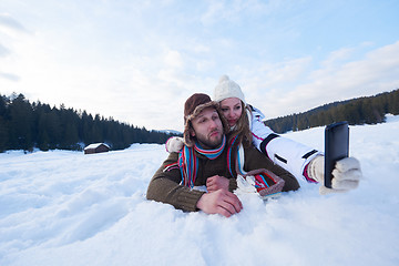 Image showing romantic couple have fun in fresh snow and taking selfie