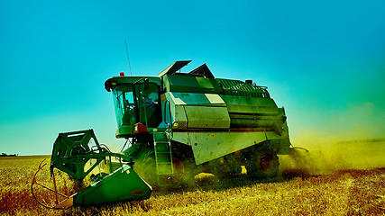 Image showing Harvester combine harvesting wheat on summer day.