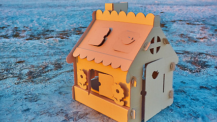 Image showing Toy house made of corrugated cardboard in the sea coast at sunset.