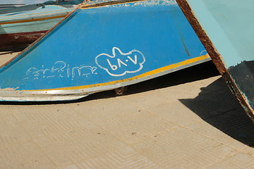 Image showing Kitten hiding under Stored wooden boat on beach_5949