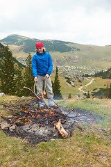 Image showing hiking man prepare tasty sausages on campfire