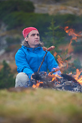 Image showing hiking man prepare tasty sausages on campfire