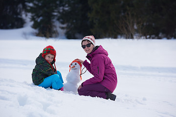 Image showing happy family building snowman