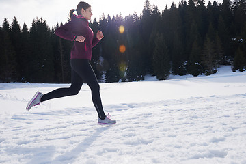 Image showing yougn woman jogging outdoor on snow in forest