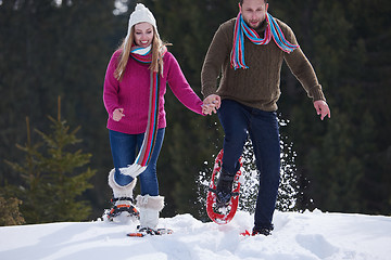 Image showing couple having fun and walking in snow shoes