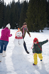 Image showing happy family building snowman