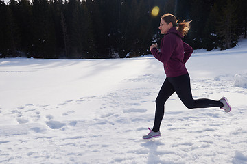 Image showing yougn woman jogging outdoor on snow in forest