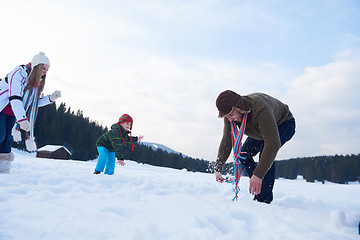 Image showing happy family playing together in snow at winter