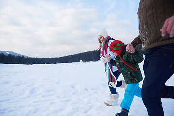 Image showing happy family playing together in snow at winter