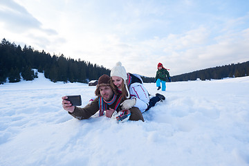 Image showing romantic couple have fun in fresh snow and taking selfie