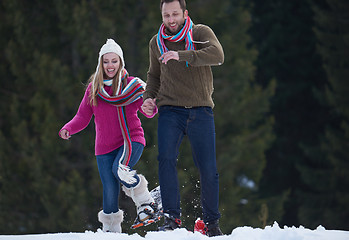 Image showing couple having fun and walking in snow shoes