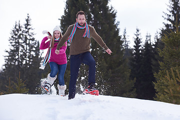 Image showing couple having fun and walking in snow shoes