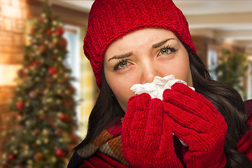 Image showing Sick Woman Blowing Her Nose With Tissue In Christmas Setting