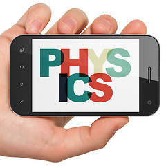 Image showing Studying concept: Hand Holding Smartphone with Physics on  display