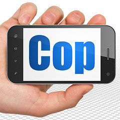 Image showing Law concept: Hand Holding Smartphone with Cop on display