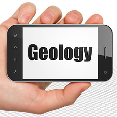 Image showing Studying concept: Hand Holding Smartphone with Geology on display