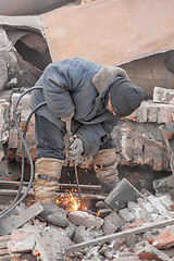 Image showing Welder using cutting torch to cut a rail