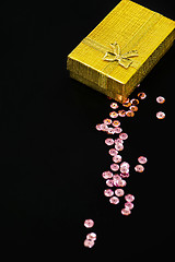 Image showing Gold christmas gift box and pink sequins