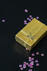 Image showing Gold christmas gift box and pink sequins