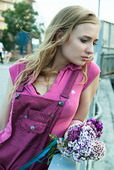 Image showing Pretty sad woman holding bouquet