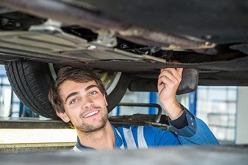 Image showing Smiling Female Mechanic Holding Car Tire