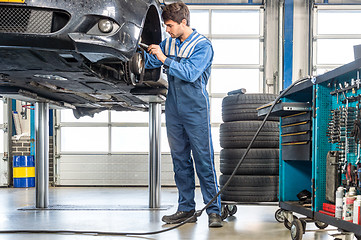 Image showing Mechanic Repairing Car On Hydraulic Lift