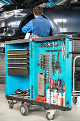 Image showing Tool Cart With Male Mechanic Repairing Car