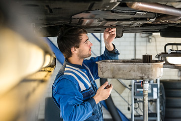 Image showing Mechanic Examining Car At Garage