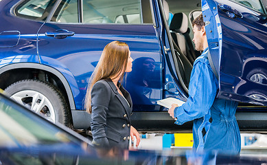 Image showing Car Mechanic With Customer Going Through Maintenance Checklist