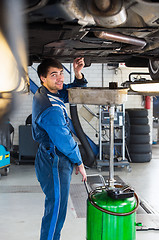 Image showing Mechanic chaning the oil of a car