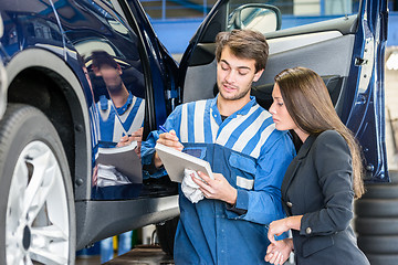 Image showing Car Mechanic With Customer Going Through Maintenance Checklist