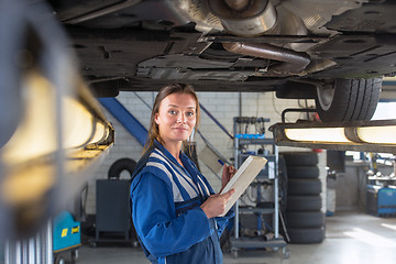 Image showing Mechanic underneath a car during a periodic examination