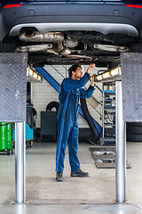 Image showing Mechanic Examining Under The Car At Garage