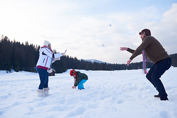 Image showing happy family playing together in snow at winter