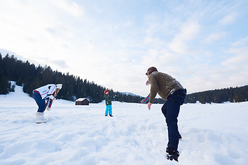 Image showing happy family playing together in snow at winter