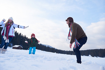 Image showing happy family playing together in snow at winter