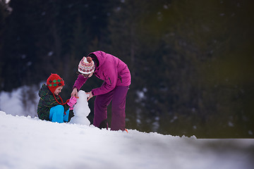 Image showing happy family building snowman