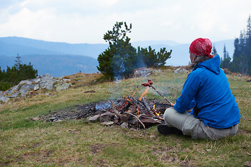 Image showing hiking man prepare tasty sausages on campfire