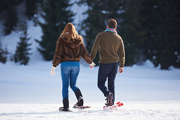 Image showing couple having fun and walking in snow shoes