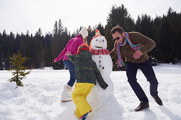 Image showing happy family building snowman